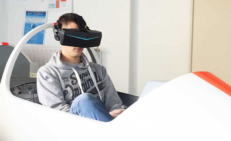 young man playing in a simulator with a virtual reality headset