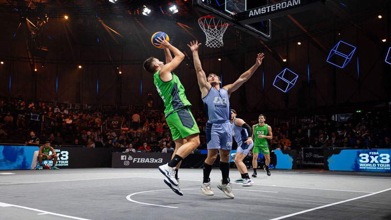 Arrêt sur image de quatre joueurs de basket-ball jouant un match de basket-ball à 3 contre 3 lors de la Paris Games Week.